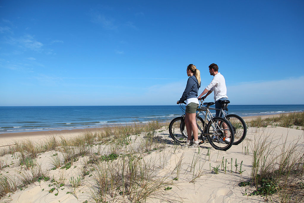 fietser die genieten van het geweldige uitzicht vanaf de duinen over de Noordzee